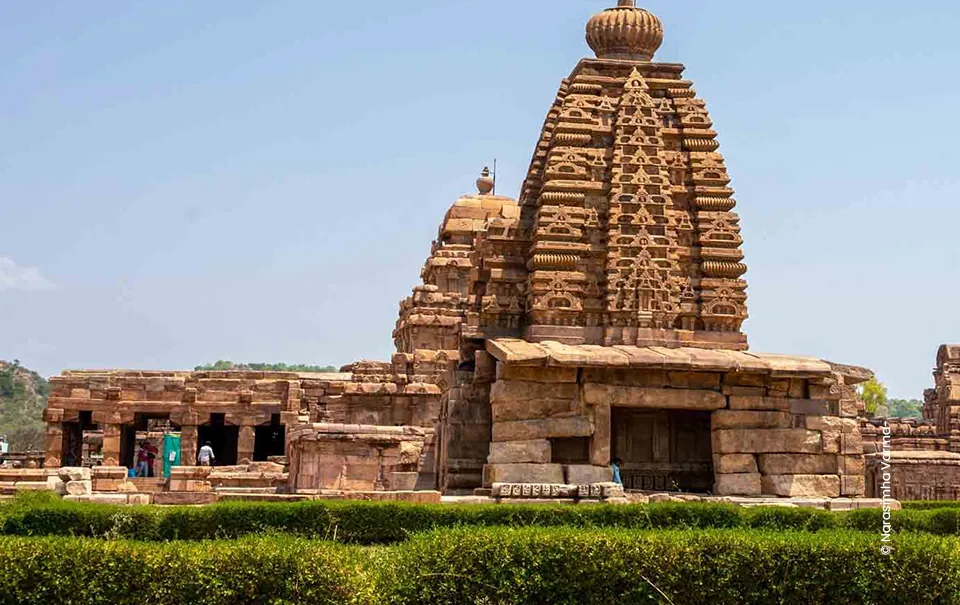 Sandstone temple tower behind green hedges, architecture photograph by Narasimha Varma, Creative Hut Academy